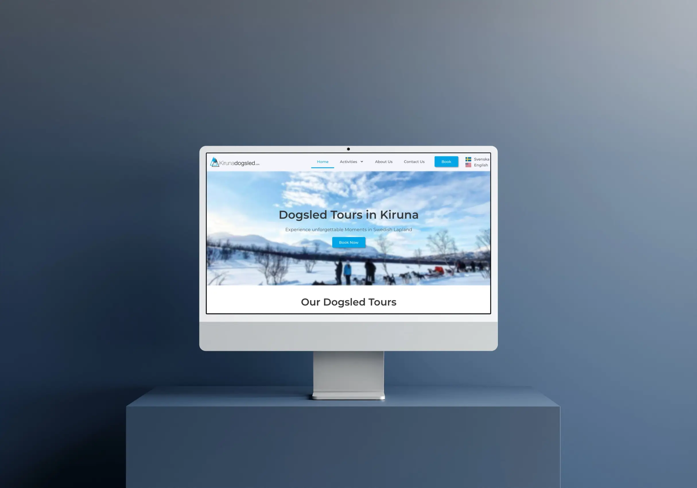 Silver iMac on the little box near the blue website
